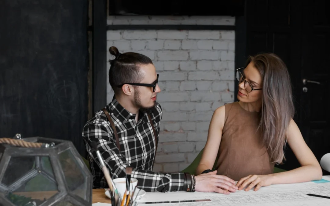 two people looking at each other at a desk