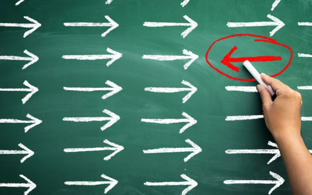 chalkboard with arrows all ran the same direction and red circle around one arrow going a different direction