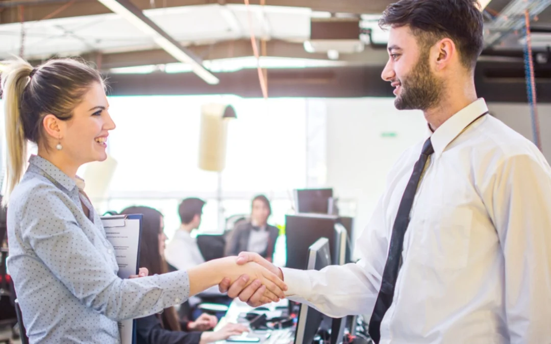 two colleagues shaking hands and smiling
