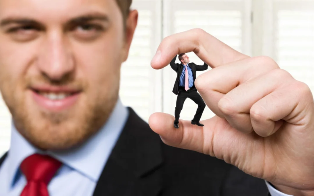man crushing tiny teammate between his fingertips