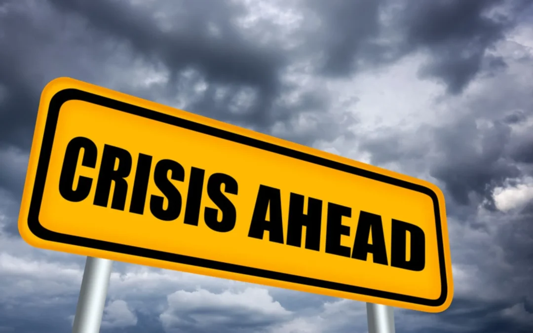 yellow sign with the words 'crisis ahead' written on it