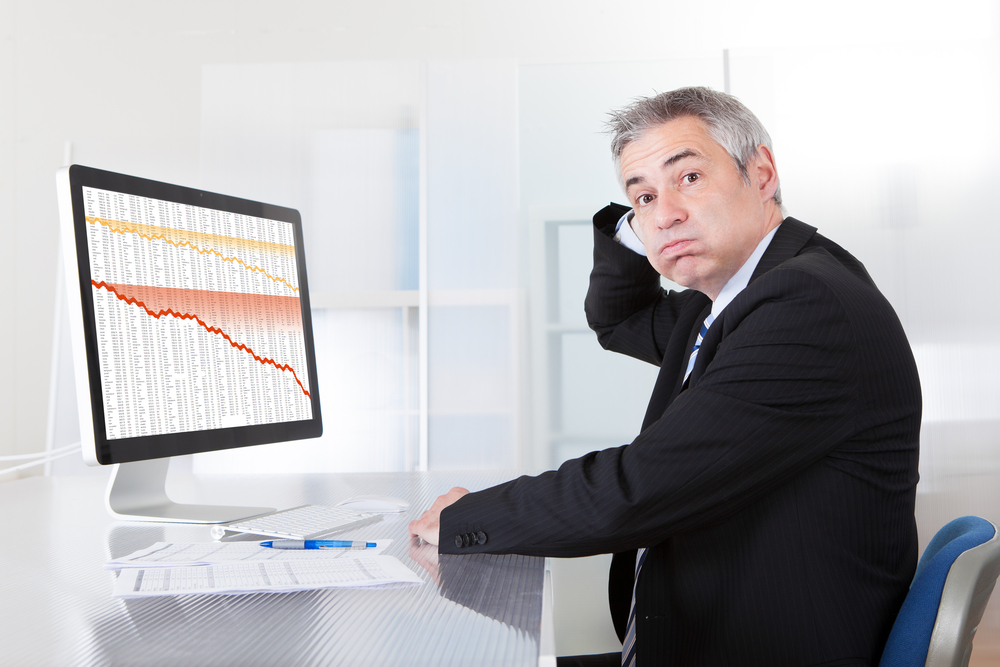 business person looking at screen of declining stock trends
