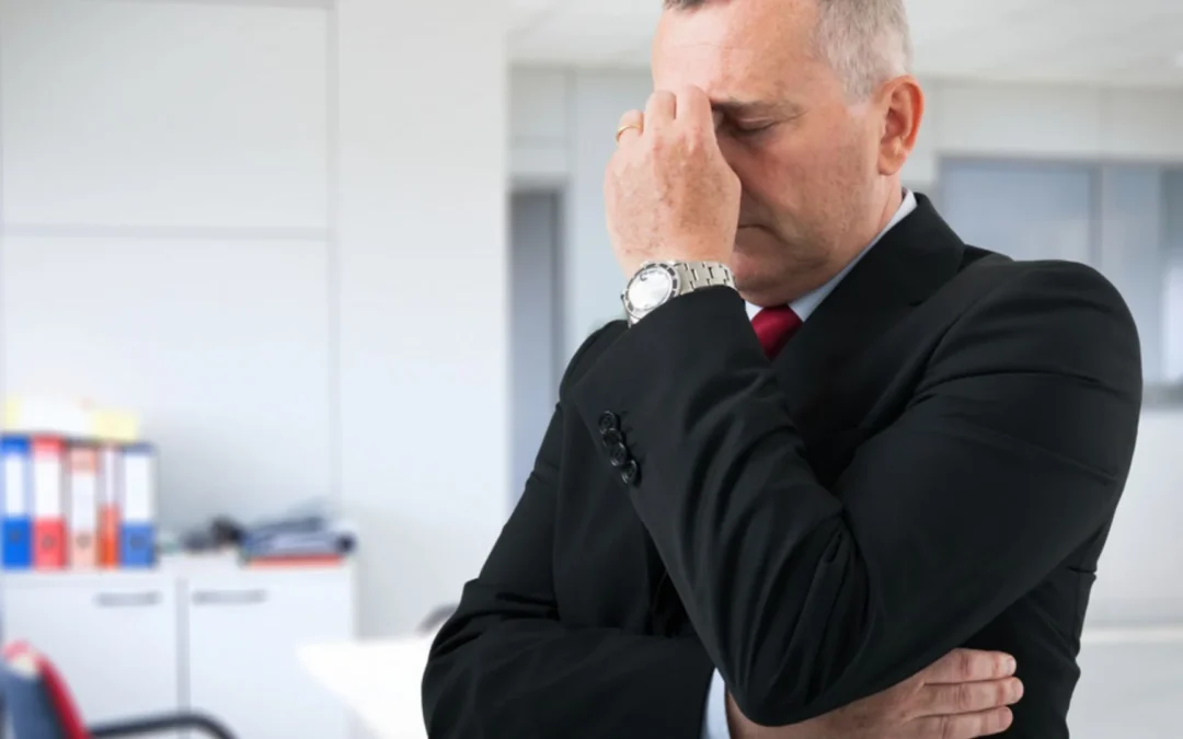 business person holding their head in their hands