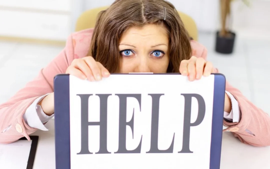 person ducking behind a sign that reads 'help'