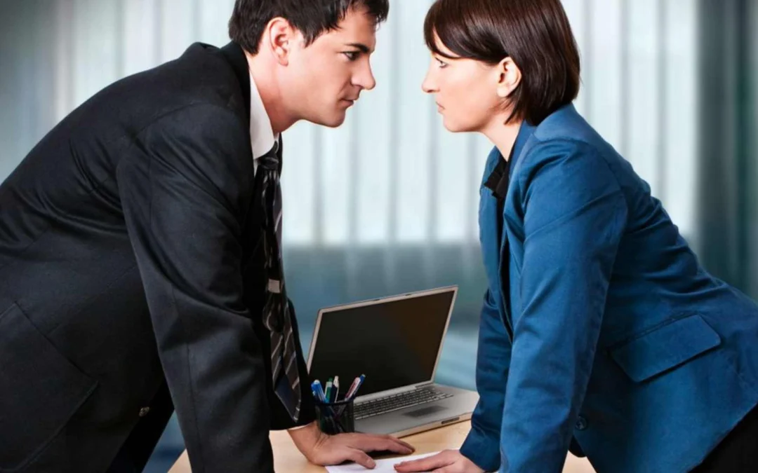 two business people staring at each other over a desk