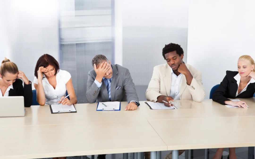 group of people looking totally bored around a meeting table