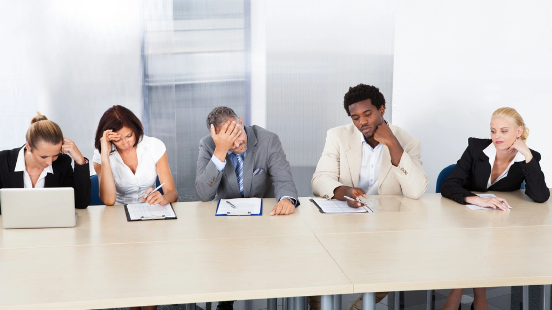 group of people looking totally bored around a meeting table
