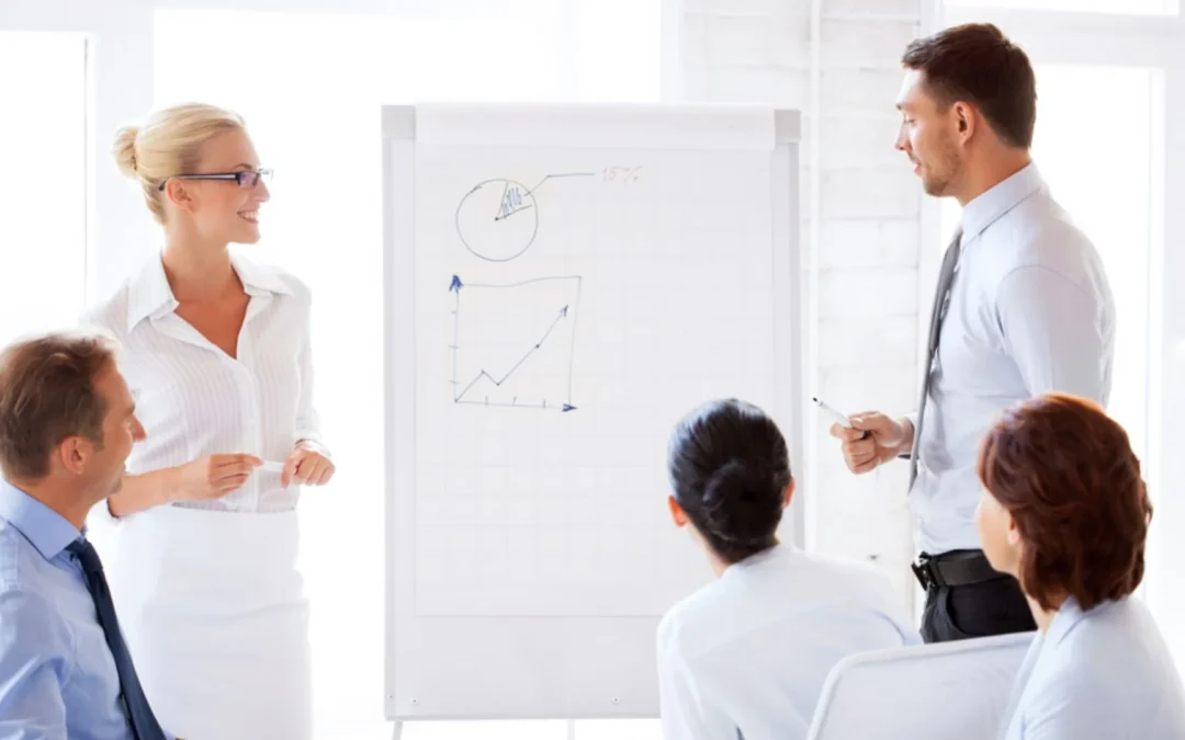 group of people standing around a flipchart
