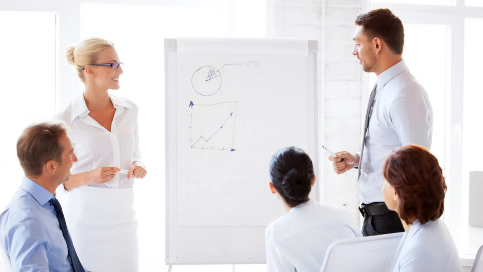 group of people standing around a flipchart