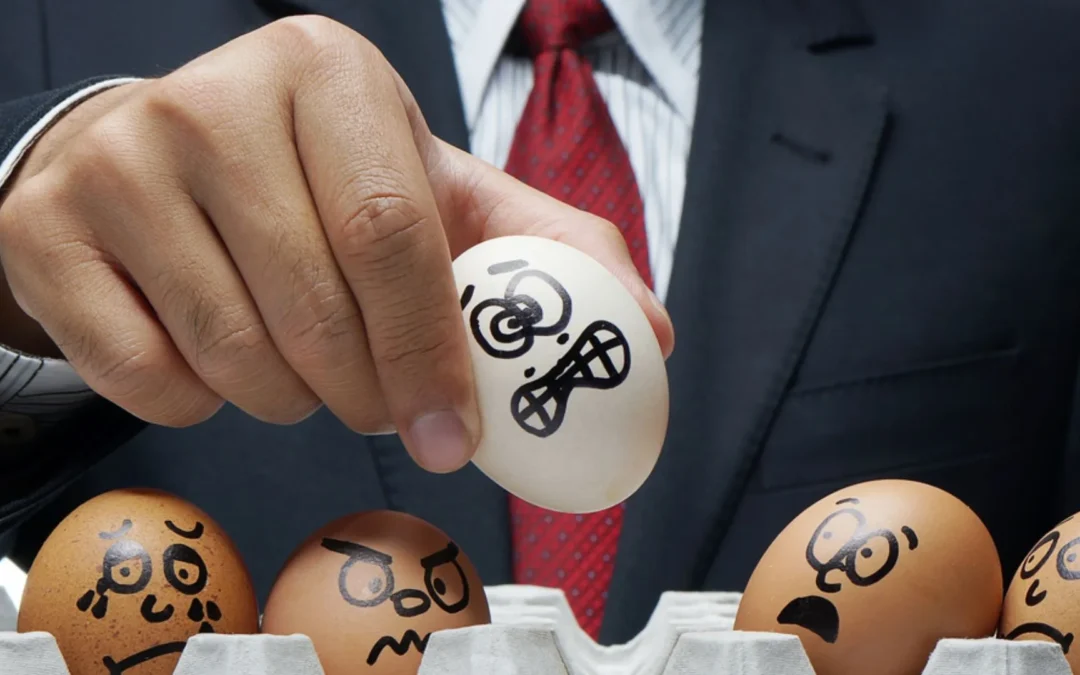 boss holding up eggs painted with scared expressions