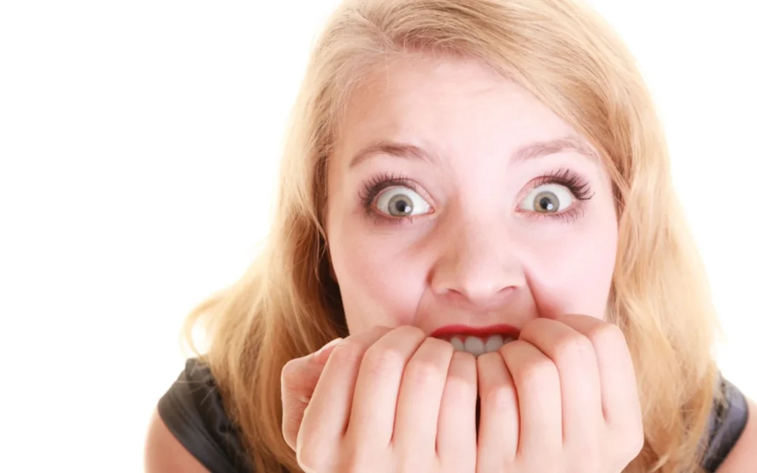 person biting fingernails looking fearful