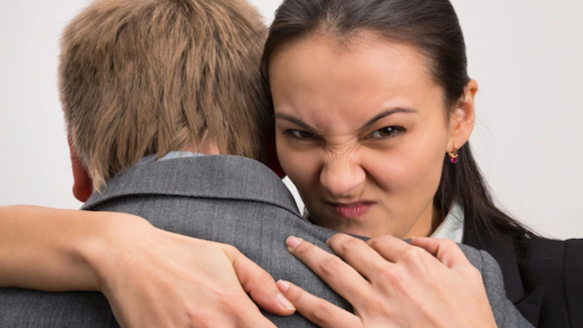 Person hugging colleague but with an evil expression