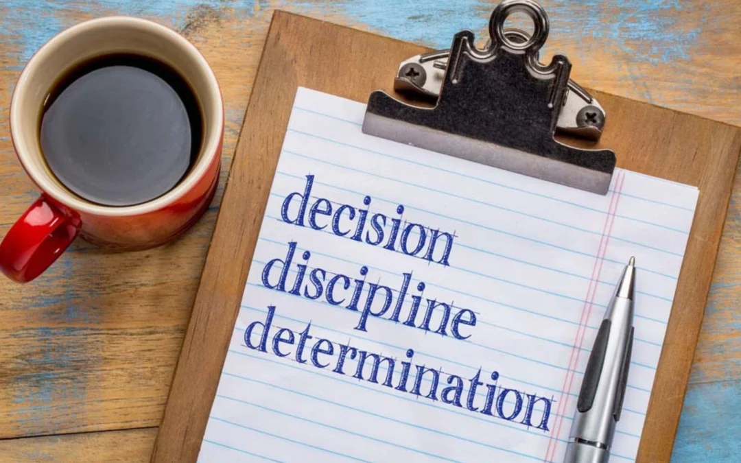 Clipboard saying "decision, discipline, determination"