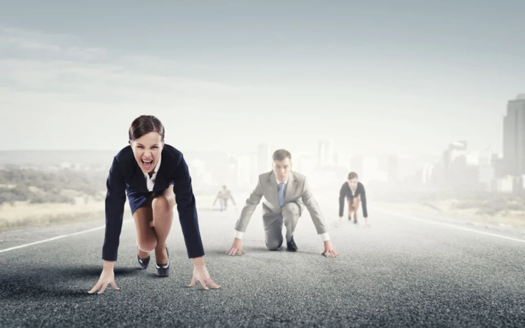 Business people in the starting blocks on a race track