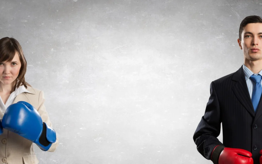 Two people in suits wearing boxing gloves