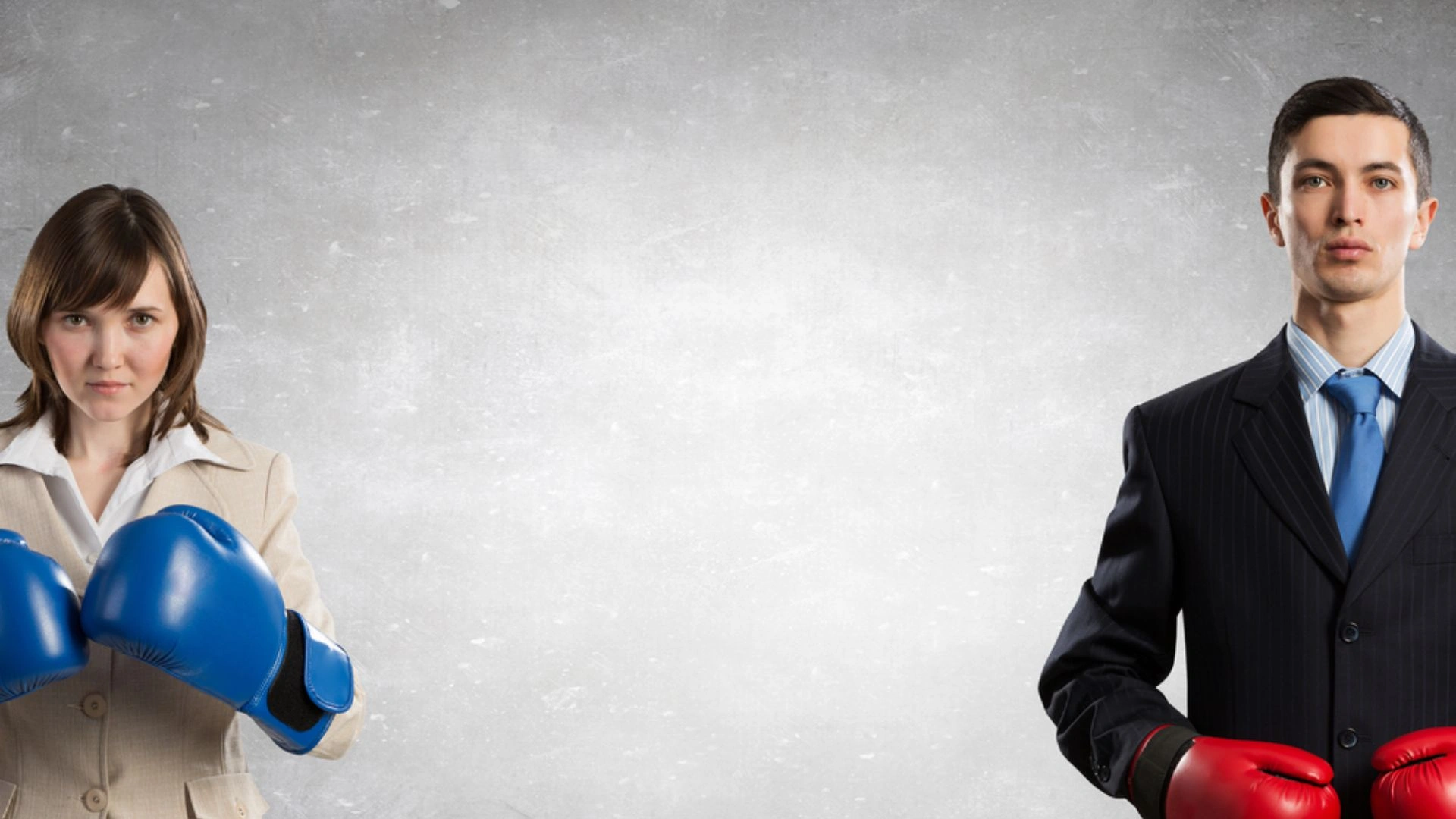 Two people in suits wearing boxing gloves