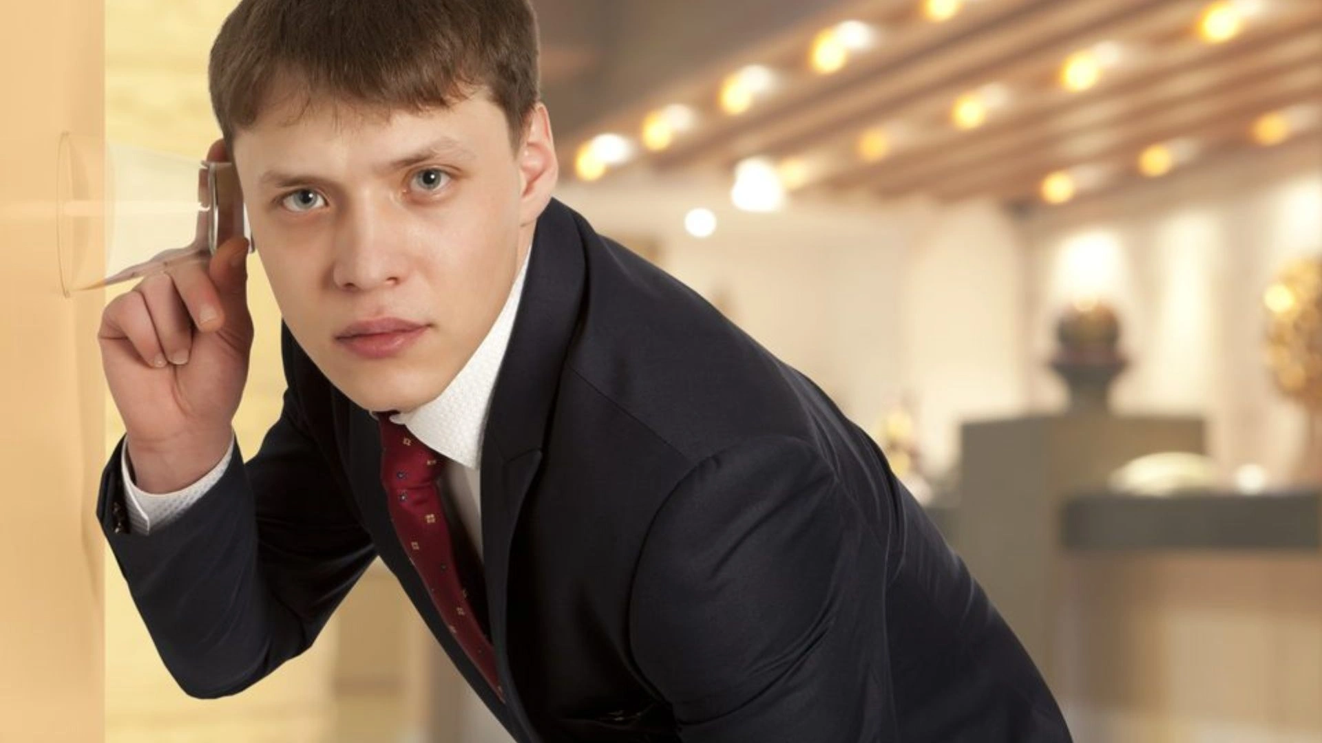Person using glass to listen at a door