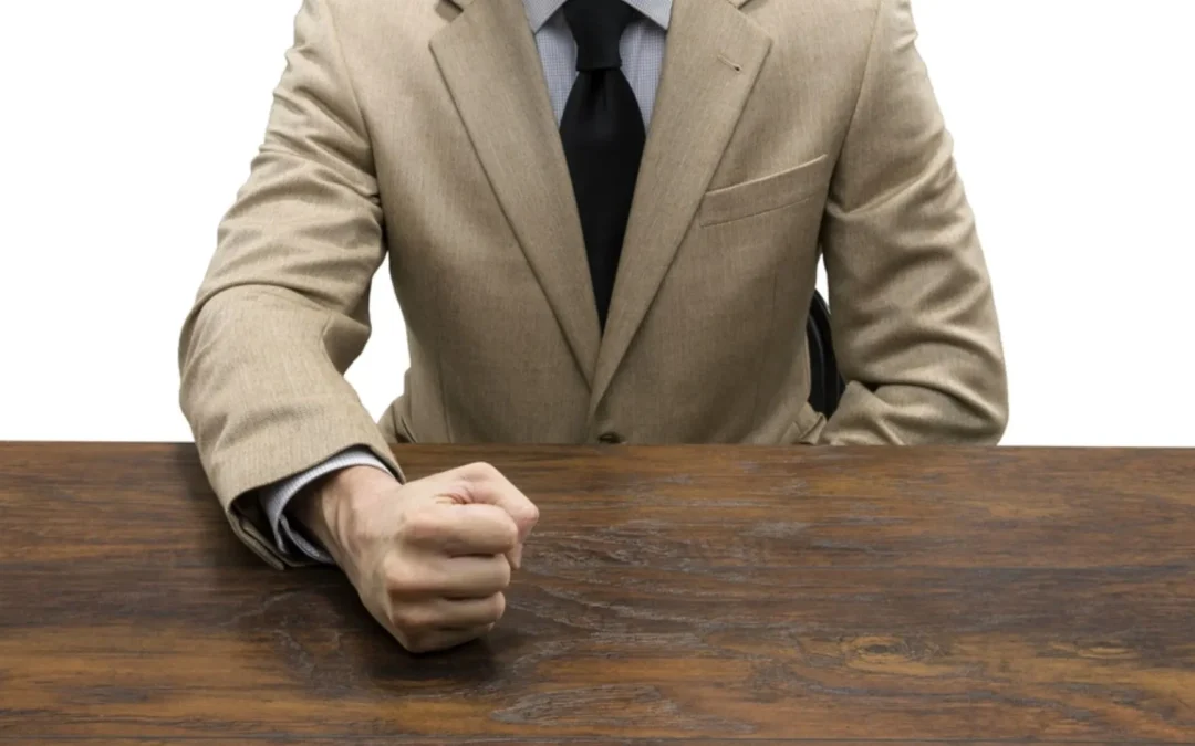 Person pounding fist on desk