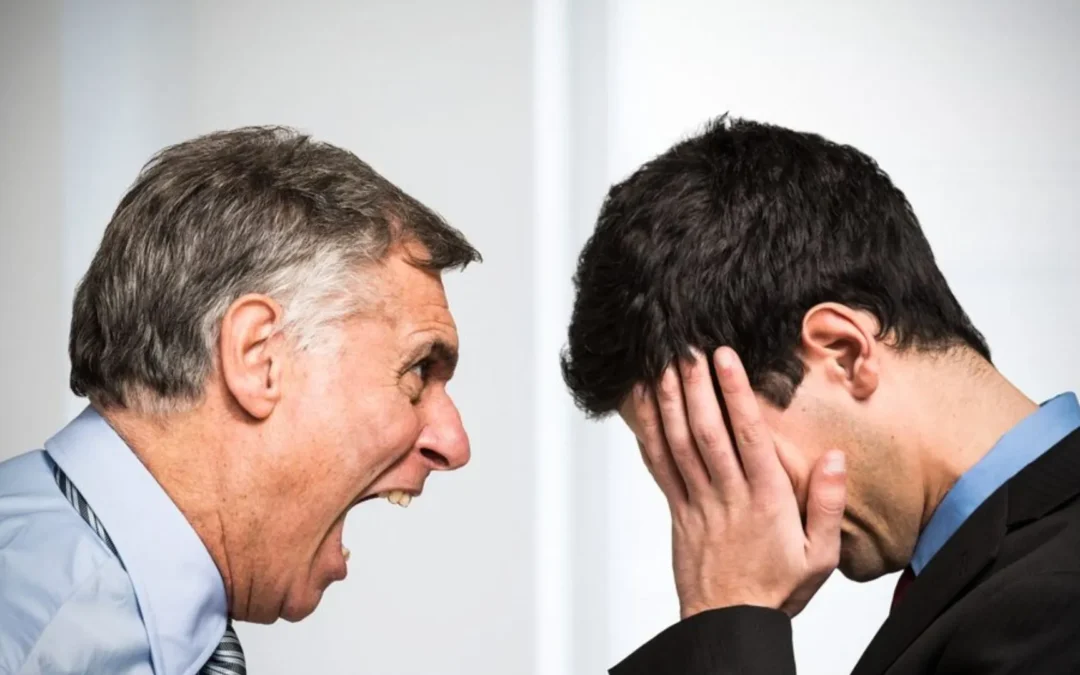 Boss yelling at a person who has his head in his hands