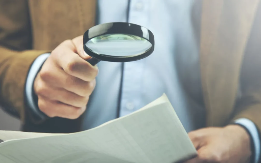 Person looking at fine print with a magnifying glass