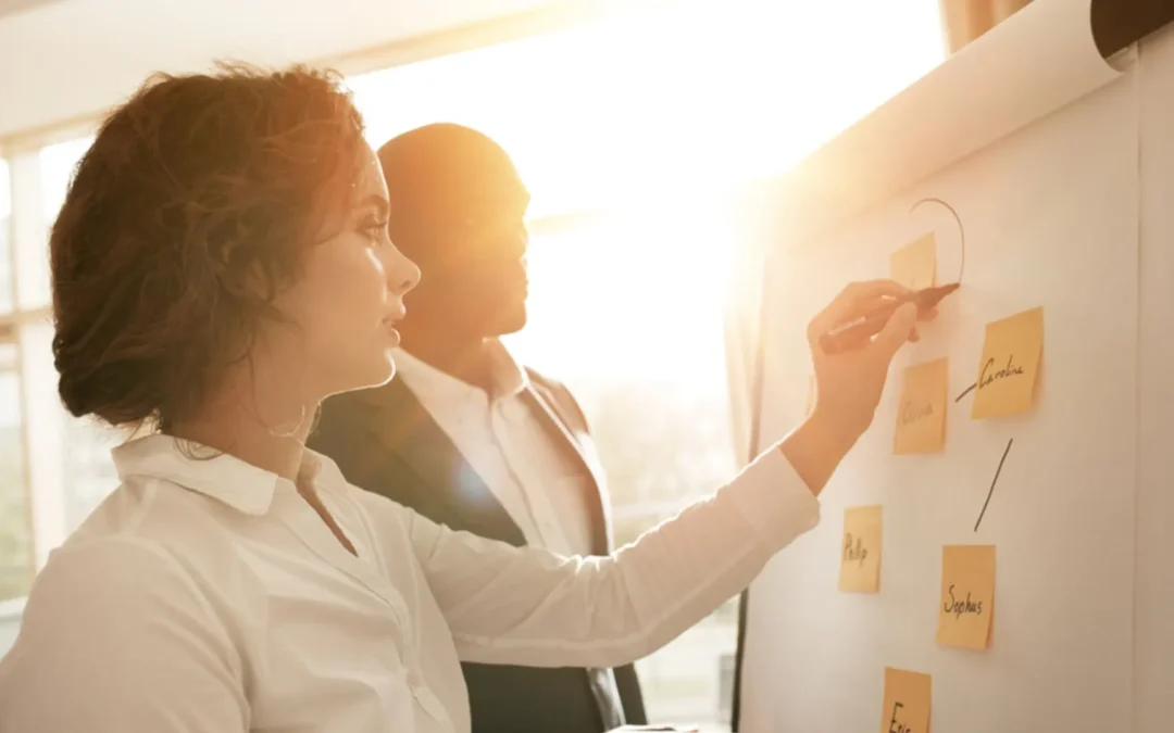 People connecting sticky notes on a flipchart