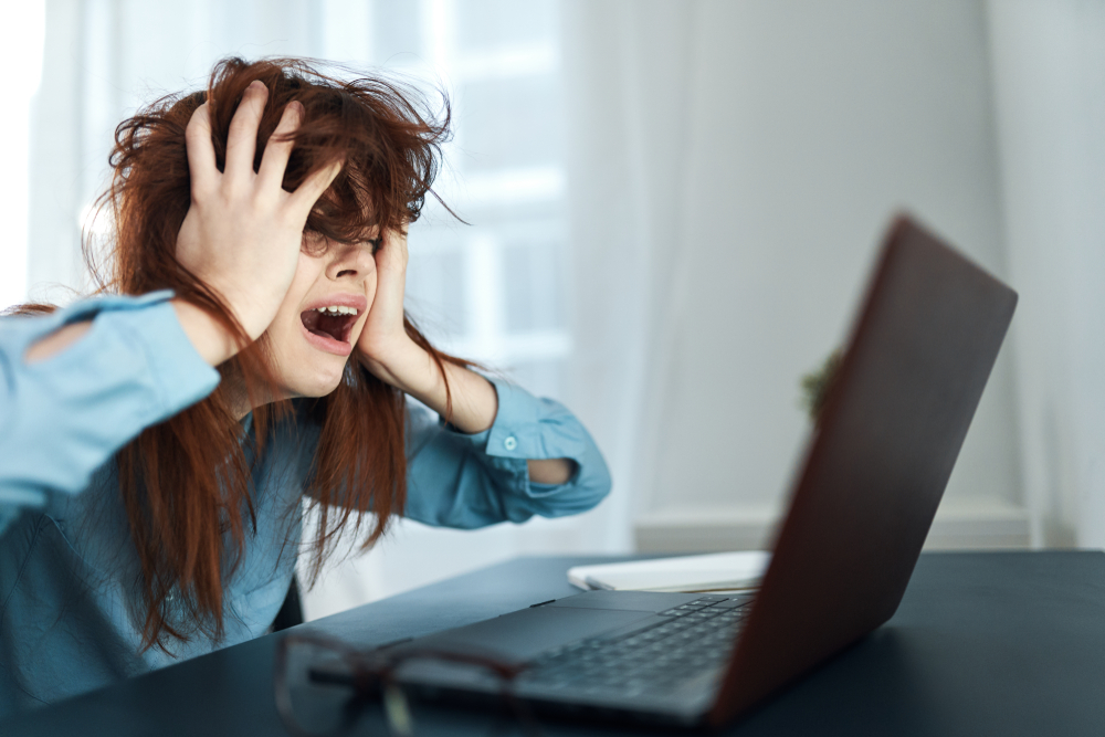 Woman looking flustered working on computer