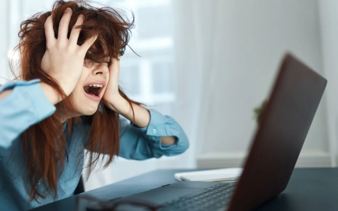 Woman looking flustered working on computer