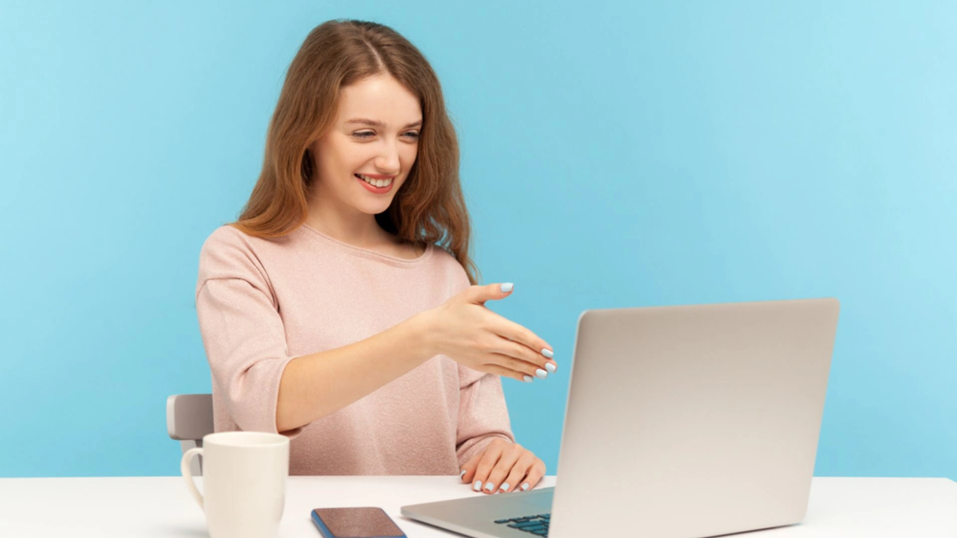 Woman pretending to shake hands over video conference