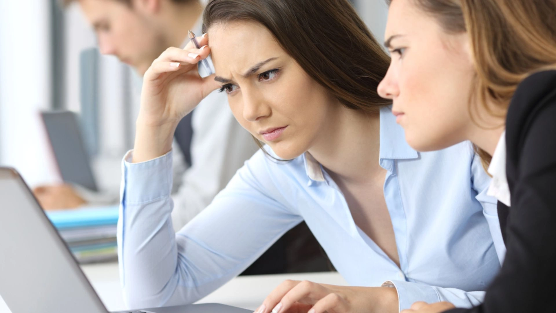 Two women looking at a laptop, concerned