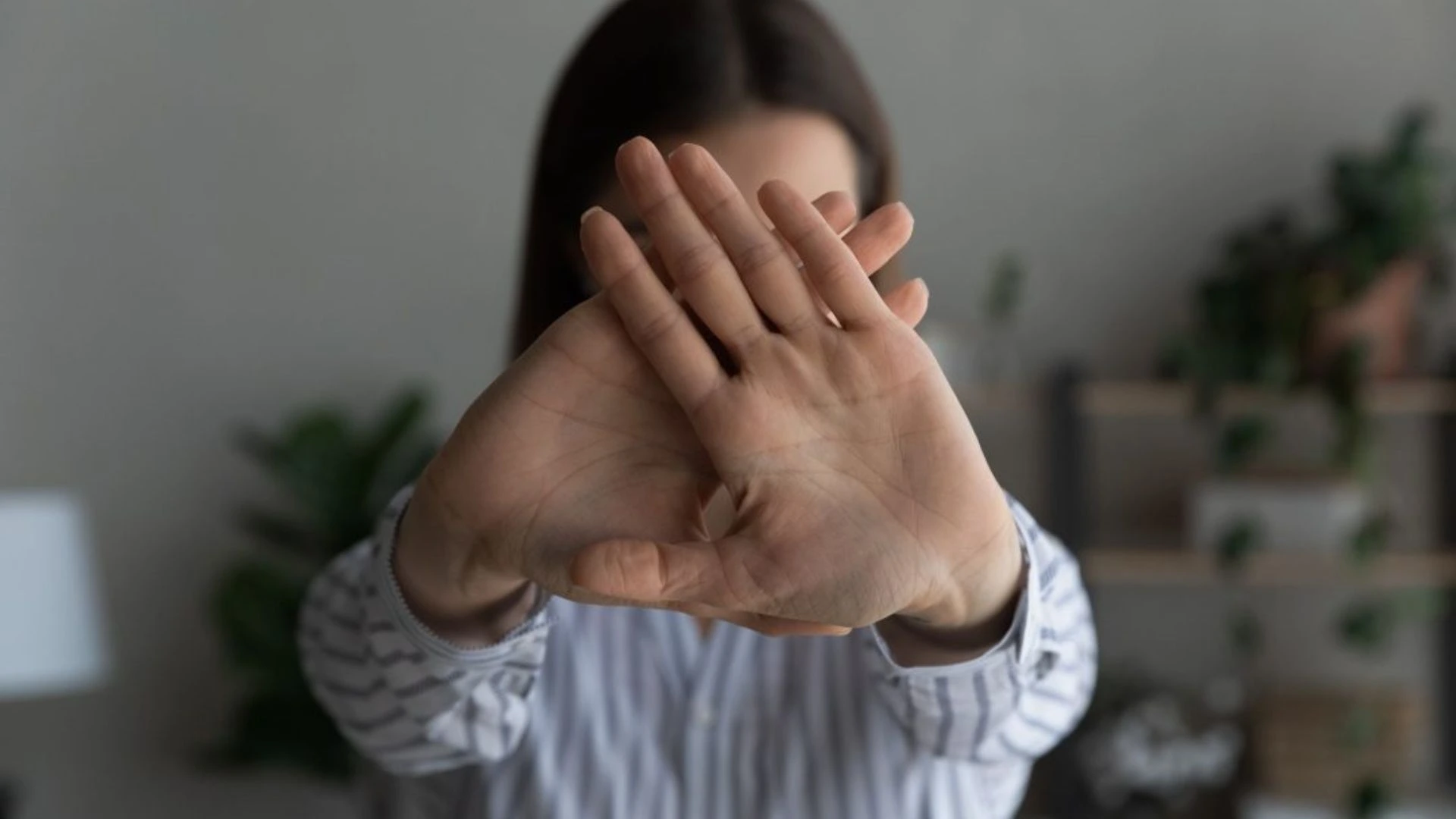 Person holding up hands to say 