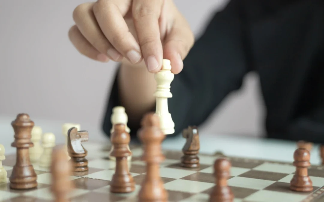 Person moving a piece on a chess board