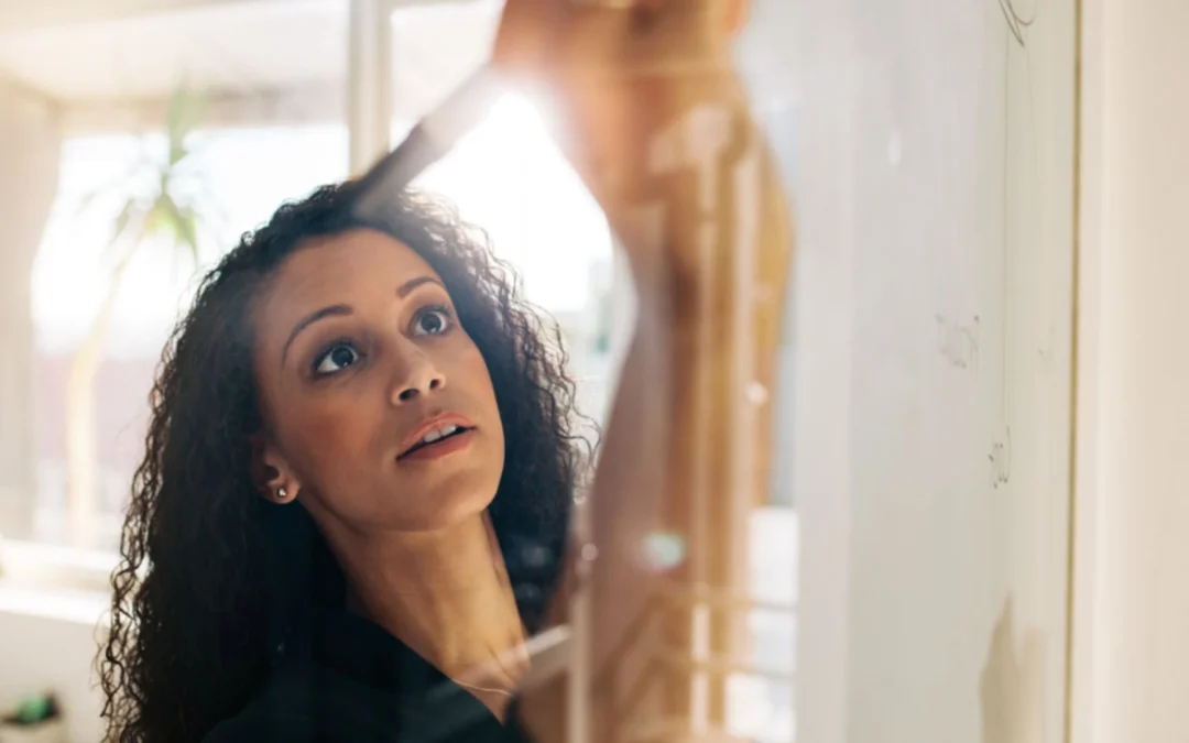 Woman writing on whiteboard