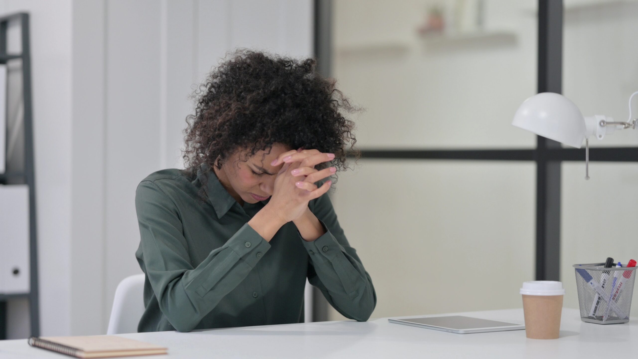 Person at a desk with head in hands