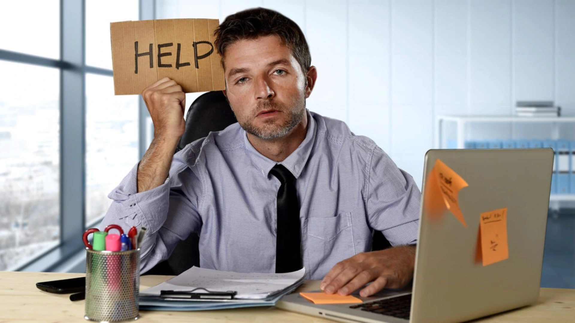 Person at computer holding up a help sign
