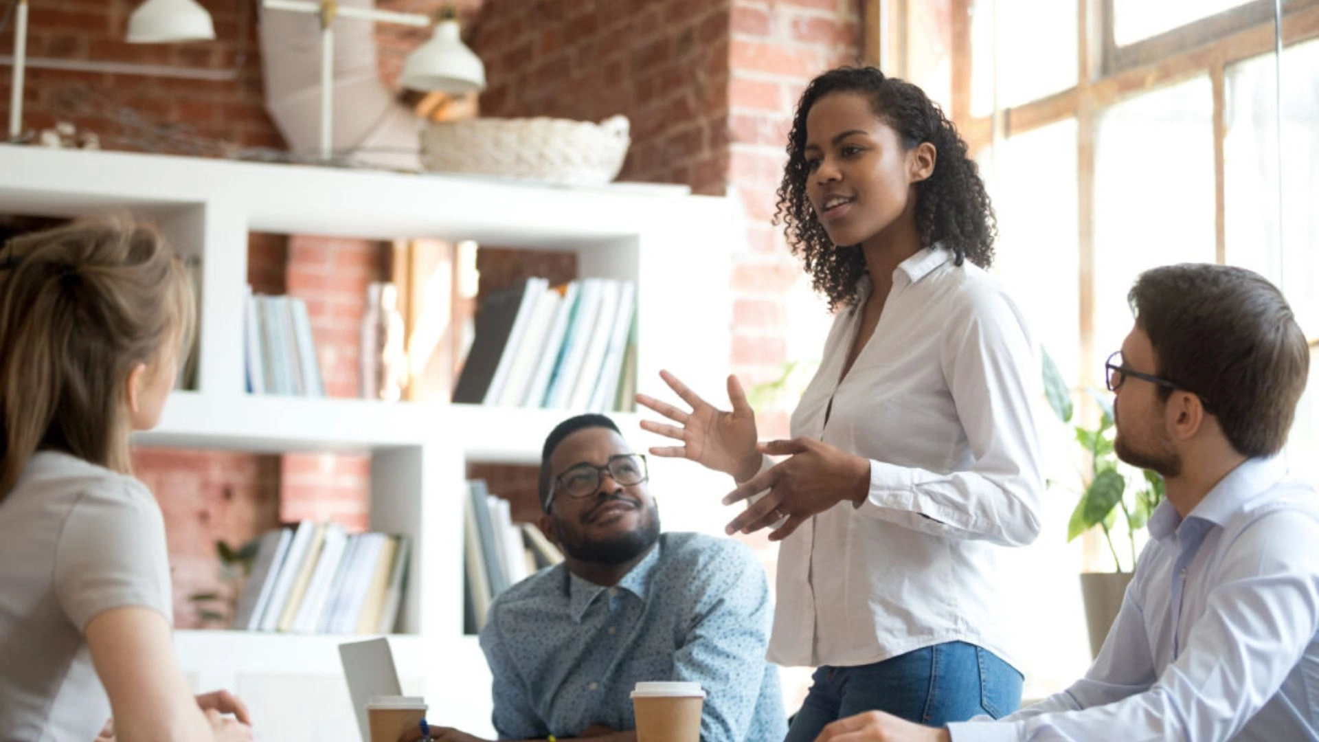 Woman standing and addressing a team in a meeting