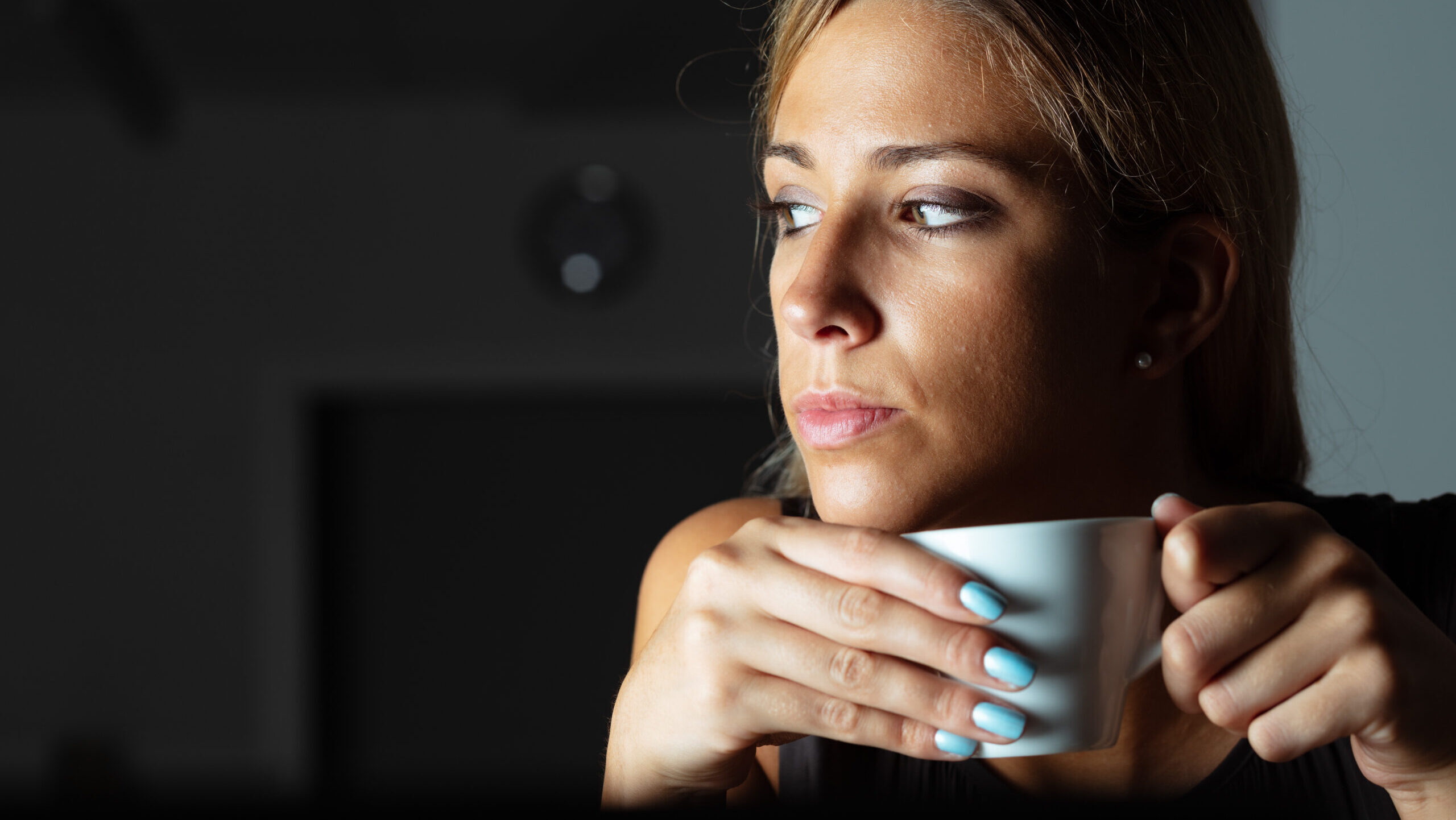 Woman drinking a coffee and looking pensive