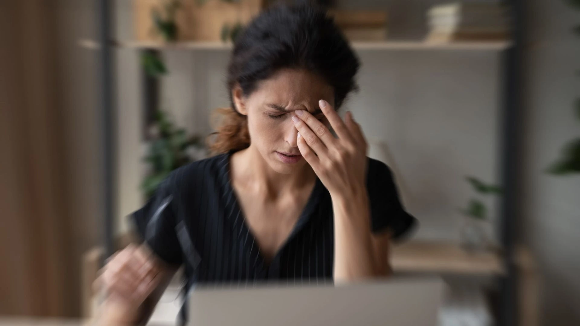 Woman holding her head, looking overwhelmed