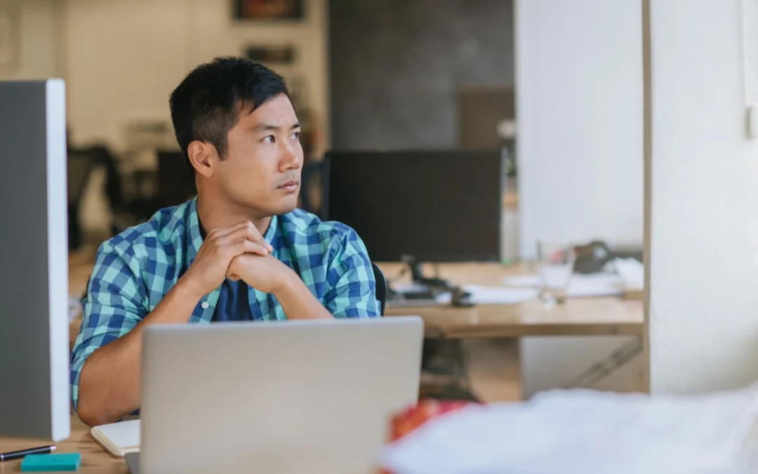 Person working at computer looking off into the distance