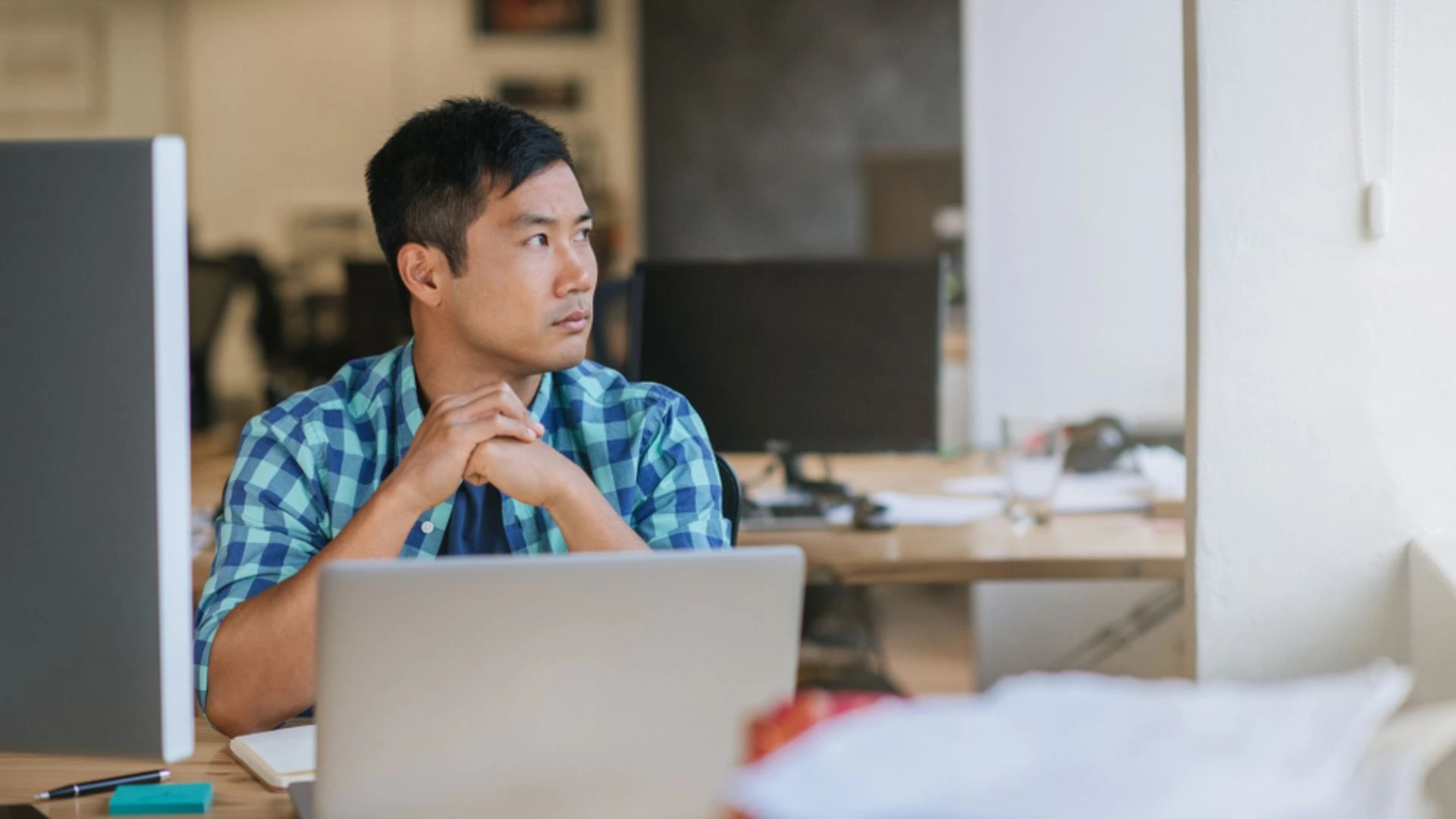 Person working at computer looking off into the distance
