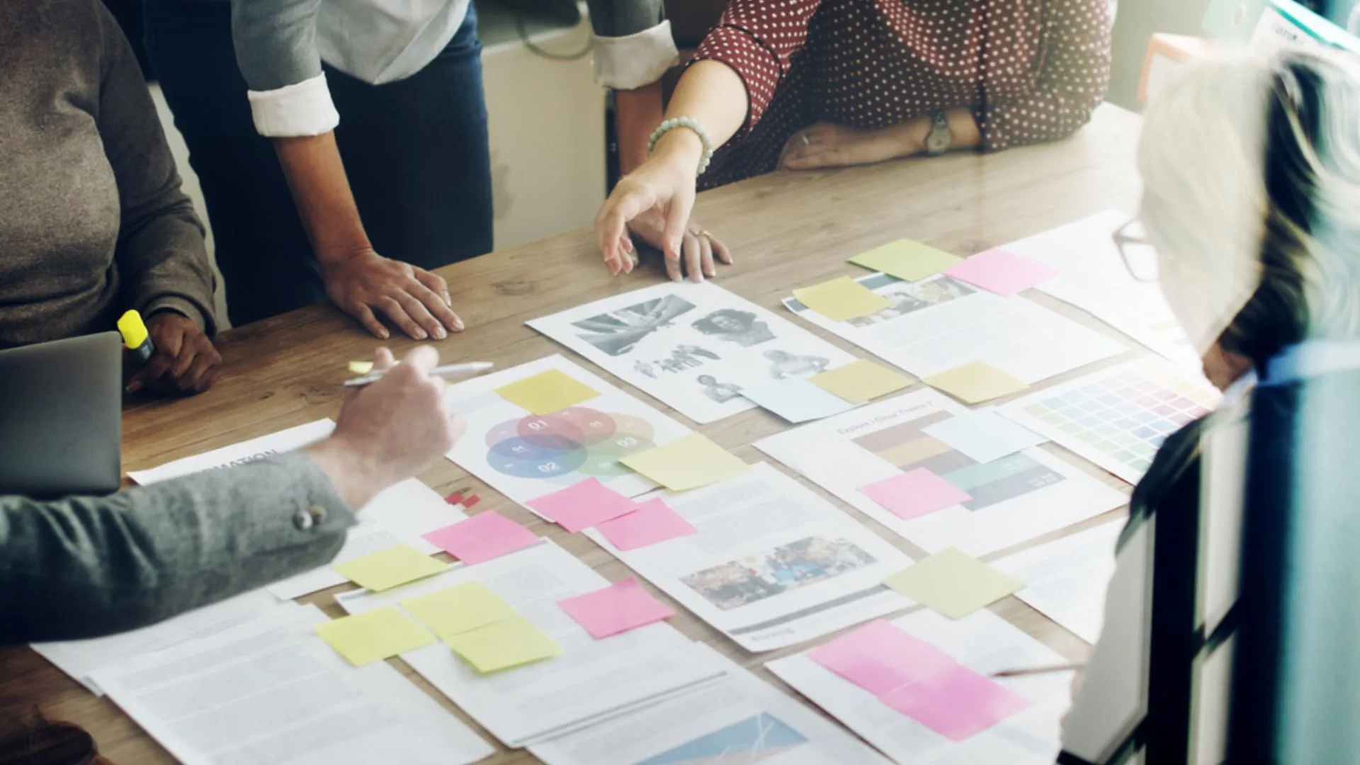 Team standing around a table full of reports