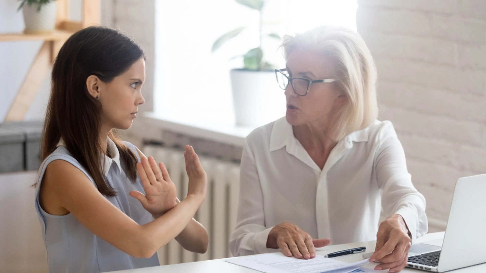 Two colleagues talking with one of them telling the other to stop