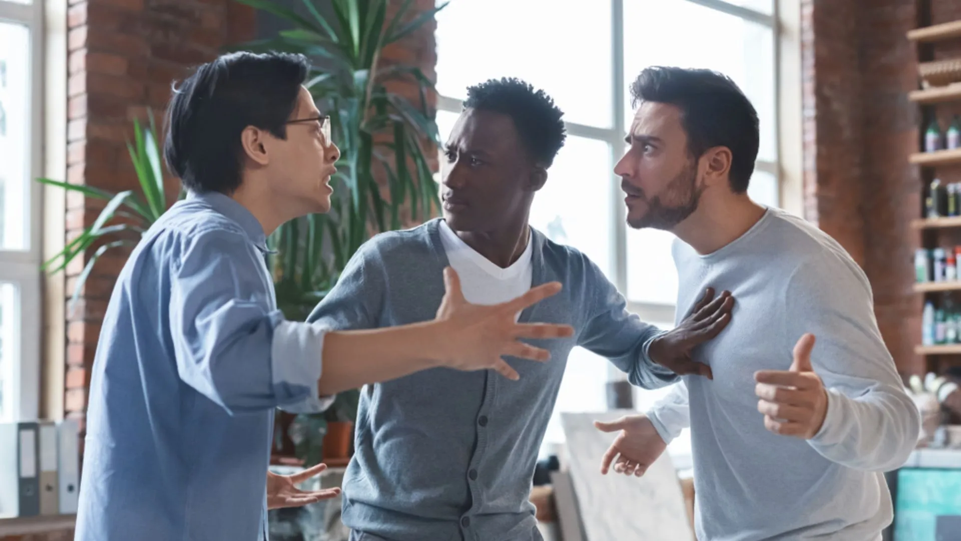 Two coworkers arguing and one trying to intervene