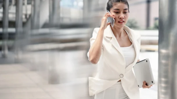 Woman talking on phone and running to a meeting