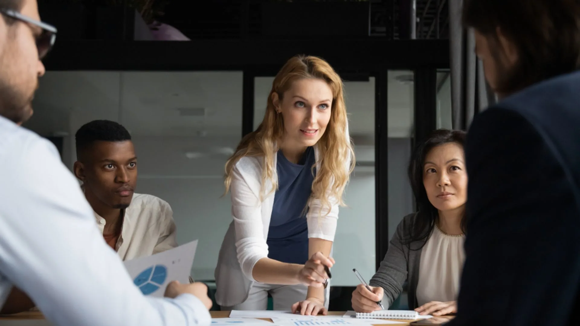 Woman leaning over a table leading a discussion