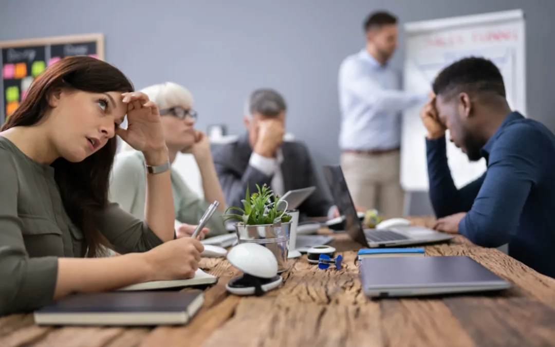 Disengaged team sitting around a meeting table