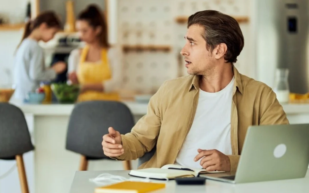 Man trying to work in an open office space but being distracted