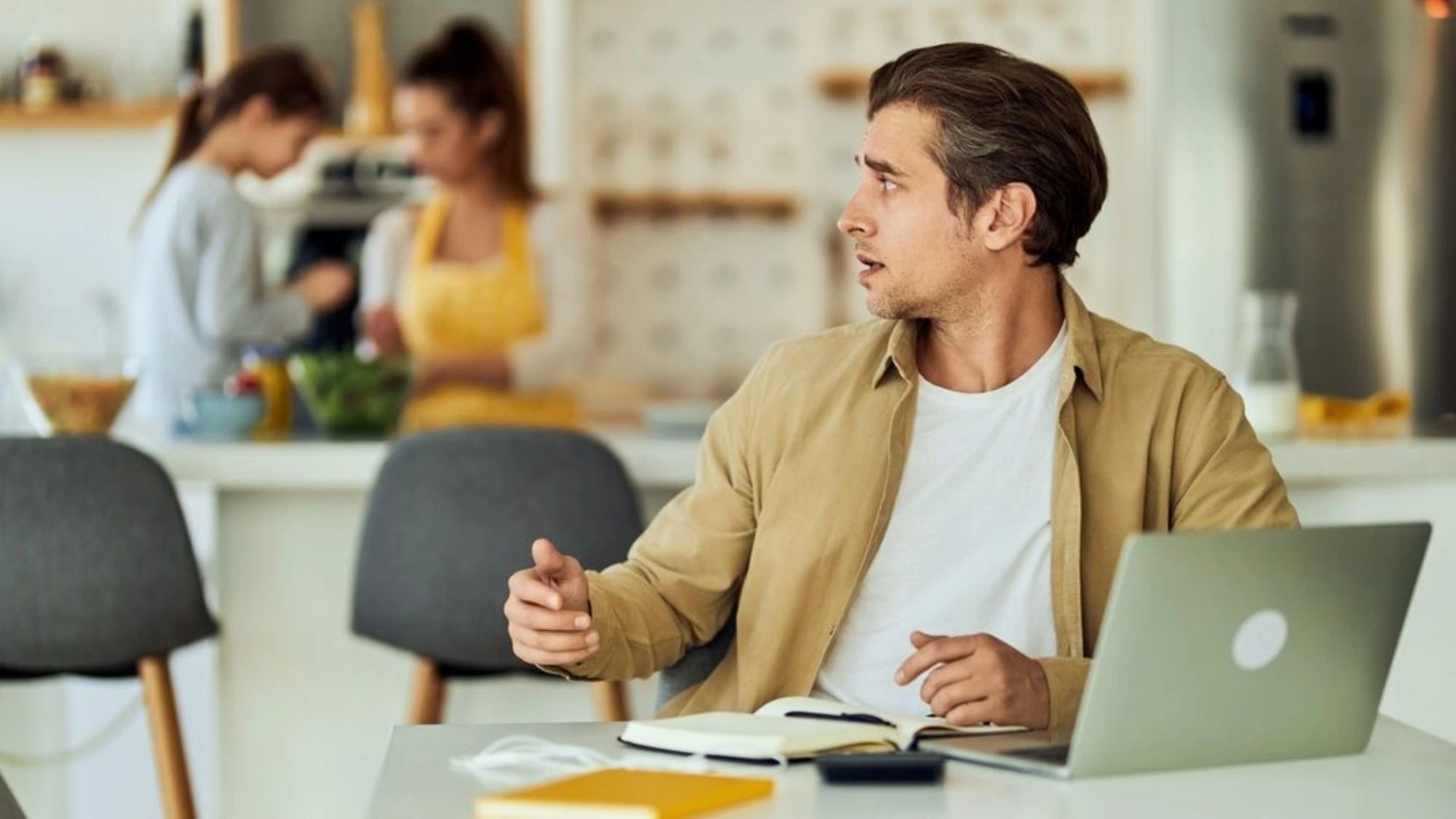 Man trying to work in an open office space but being distracted
