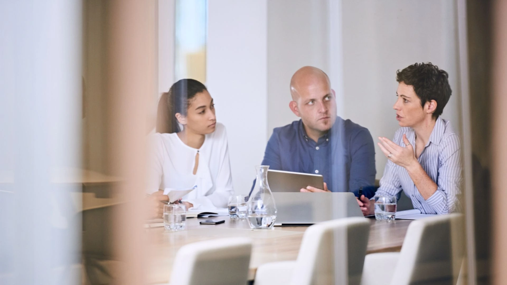 Team meeting viewed from outside the glass walls. No boss present.