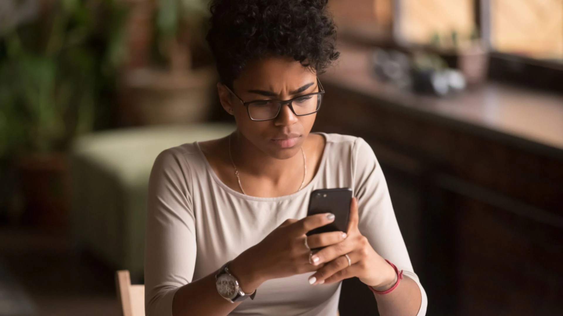 Woman looking at her phone looking confused by the message