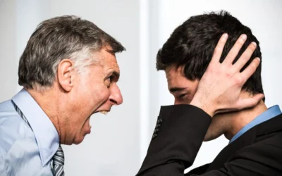 One colleague yelling at another while the receiver covers his ears with his hands.